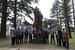 Foto de familia junto a la talla de madera que simboliza la necesidd de protección de los bosques