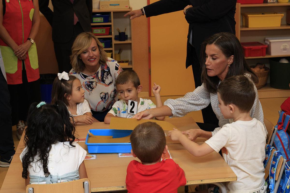 La ministra de Educación, Formación Profesional y Deportes, Pilar Alegría, y la reina Letizia junto a varios niños 