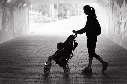 Madre pasea a su hijo en coche de bebé.