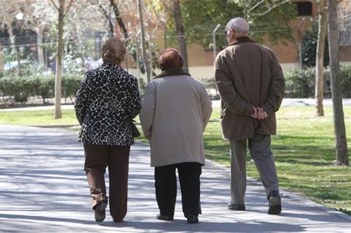 Tres jubilados paseando por un parque