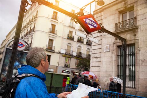 Turista consulta un plano junto a la parada de metros de Sol.