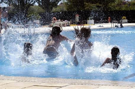 Menores jugando en una piscina